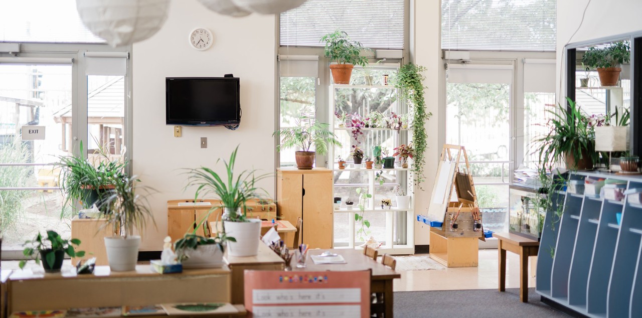 Image displaying an elementary classroom filled with group work tables and chairs.