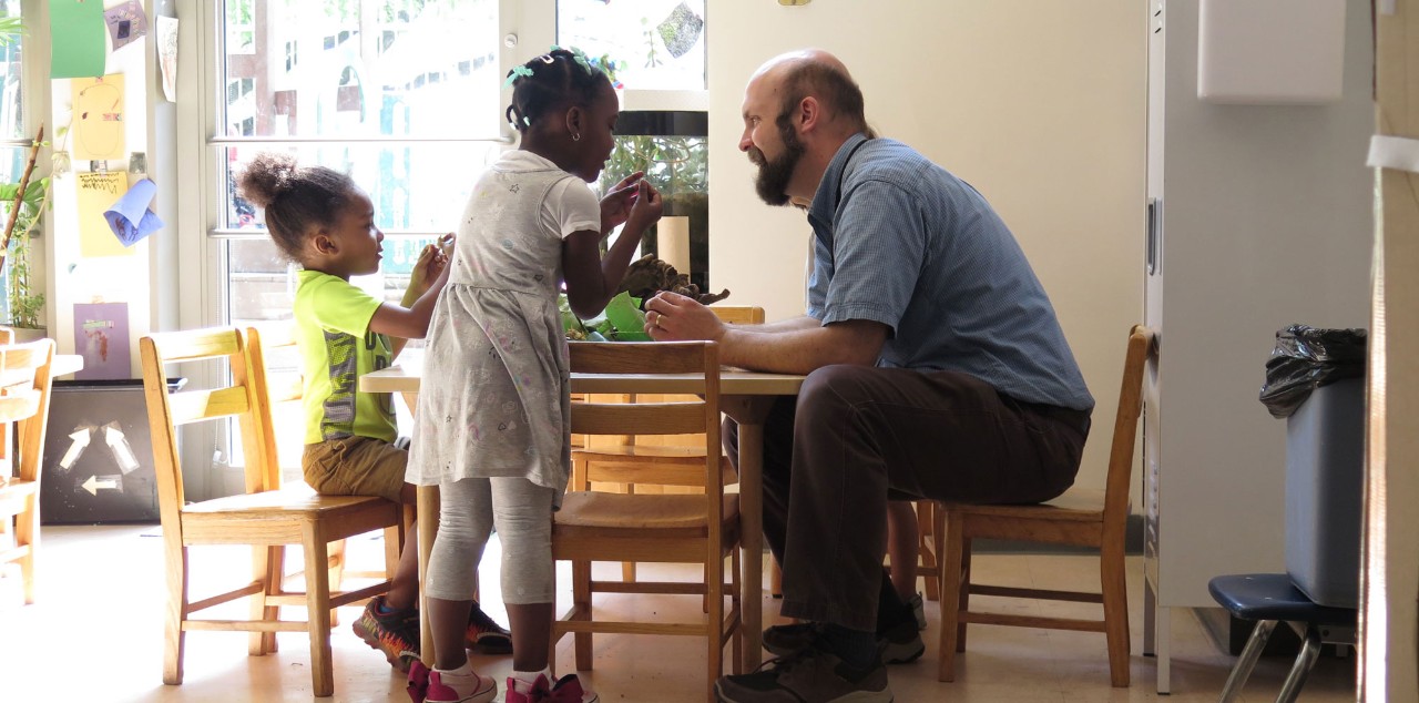 Image of a teacher working with two students