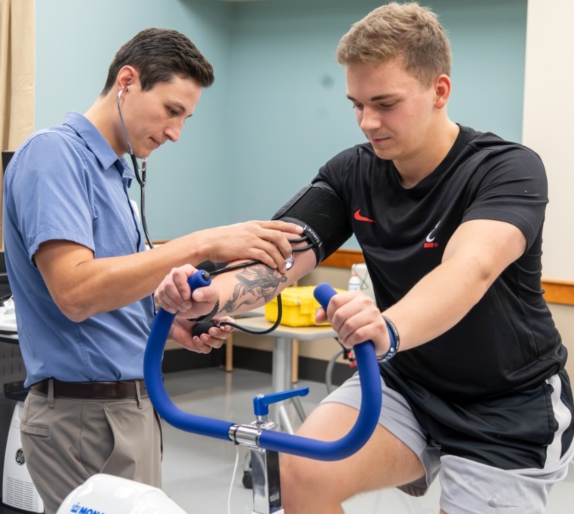 Professor checking vitals of a CECH student