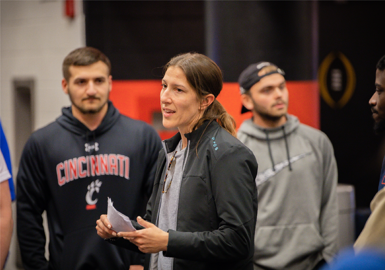UC Faculty talking with a group of students.