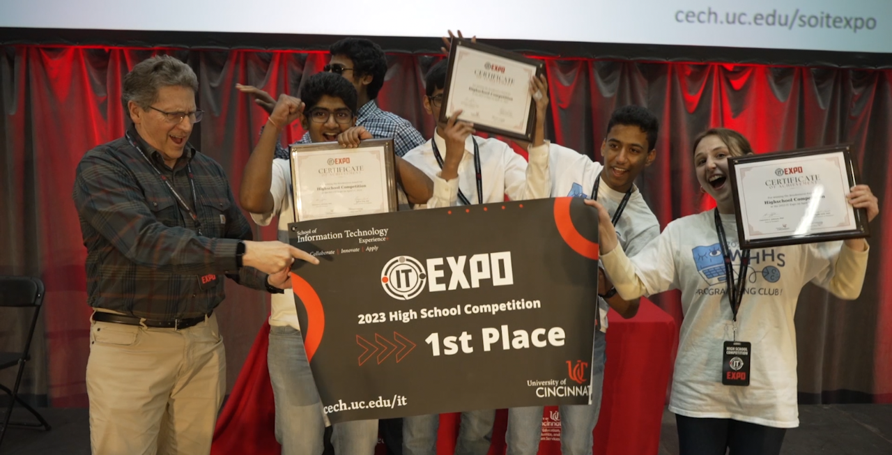 Group of students smiling with a first place banner and certificates.